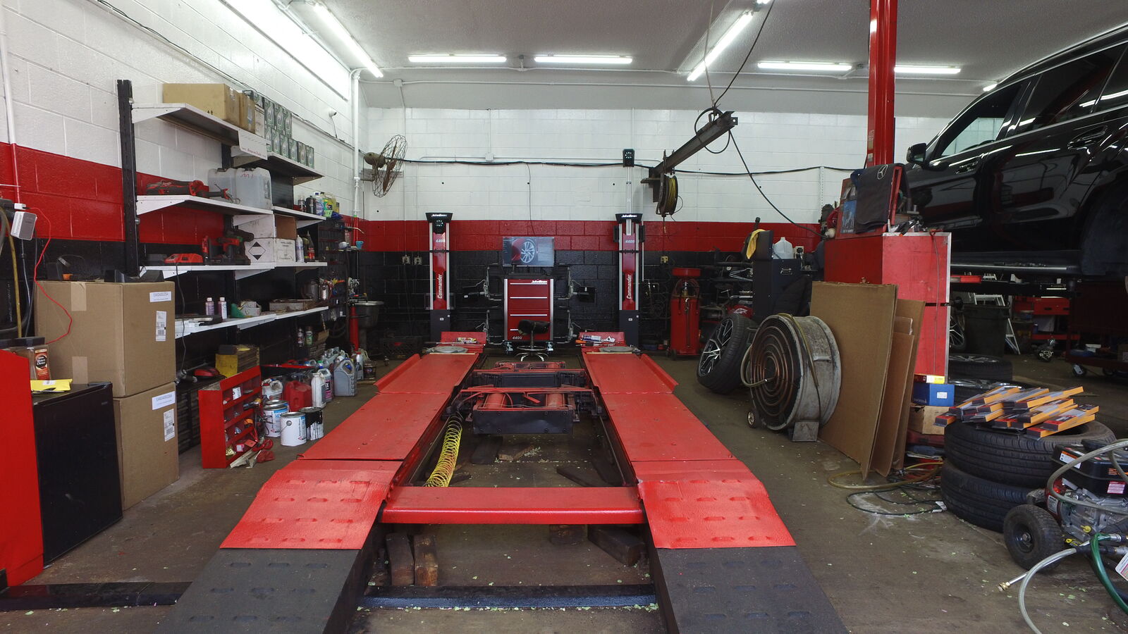 Technician servicing a vehicle on the alignment lift inside Euro Auto Mall's service bay in Cliffside Park, NJ